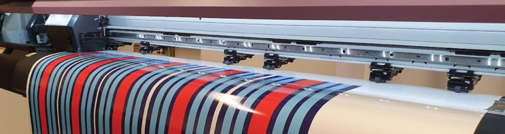 Mimaki printer producing custom decals and stickers in blue, red and white for professional graphic applications