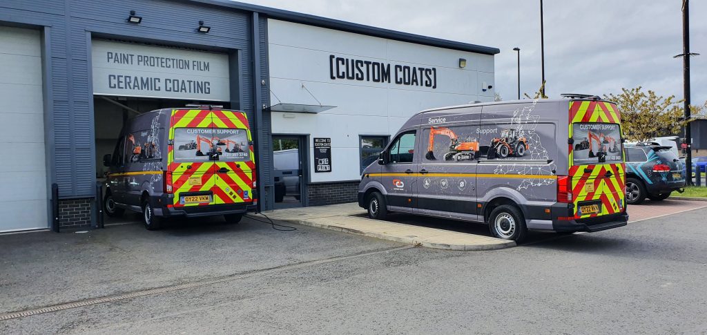 Commercial vans fitted with reflective rear chevron kits and high-visibility safety markings outside a professional vehicle graphics studio in Newcastle
